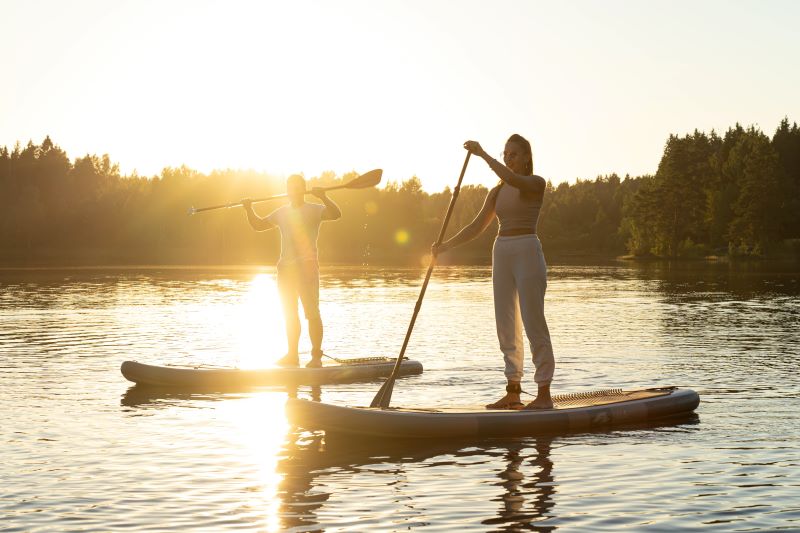 Two people paddleboard on a lake